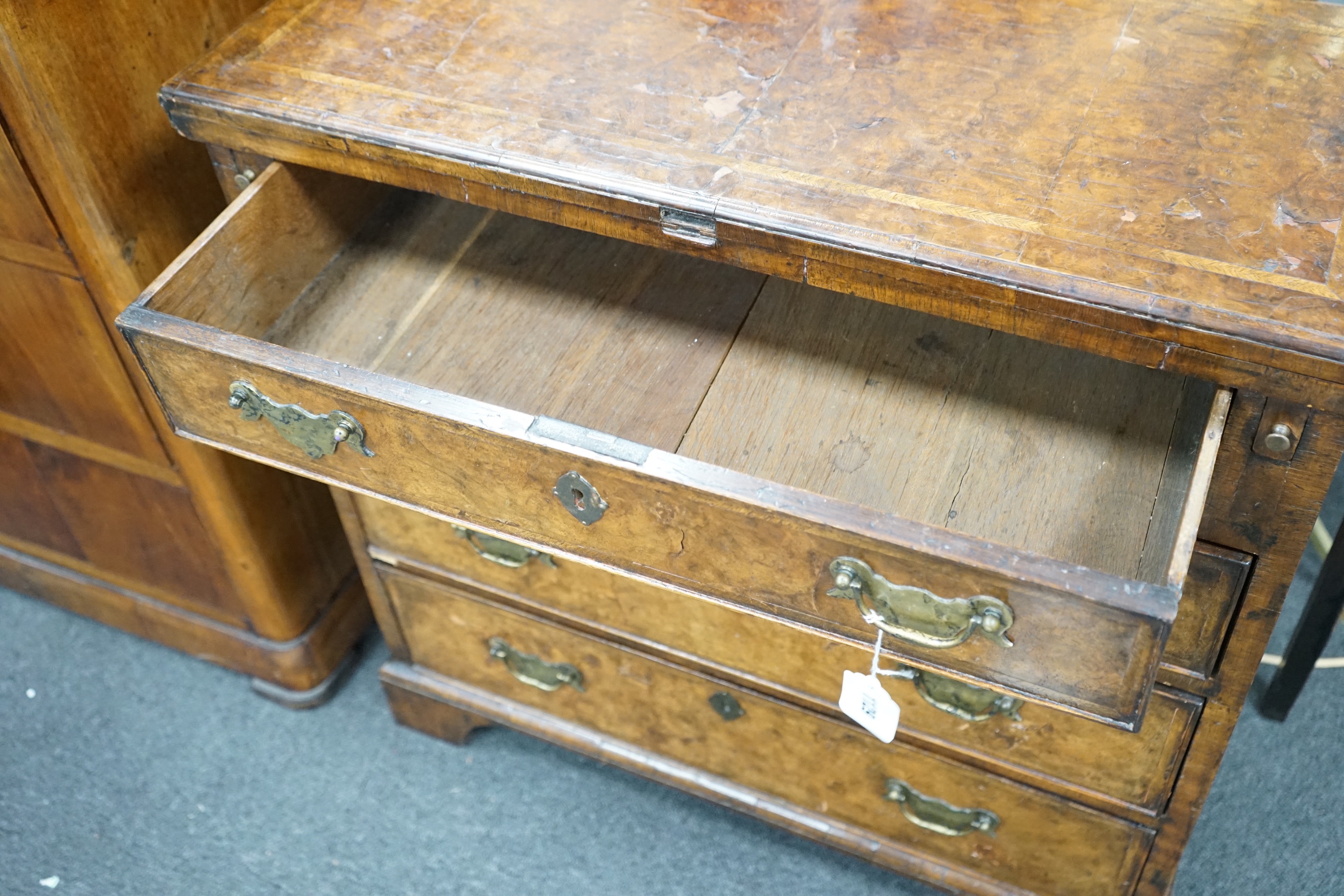 An early 18th century style feather banded walnut bachelor's chest, width 76cm, depth 34cm, height 75cm